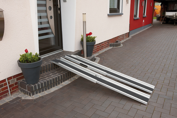 Senior nutzt Rollstuhlrampen in Lübecker Wohnhaus